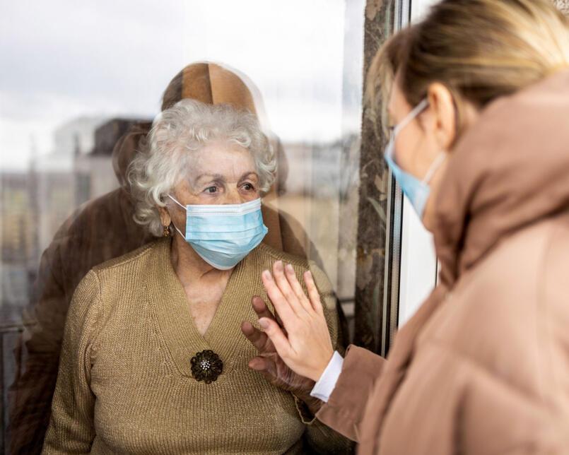 A woman visiting her elderly mother during lockdown