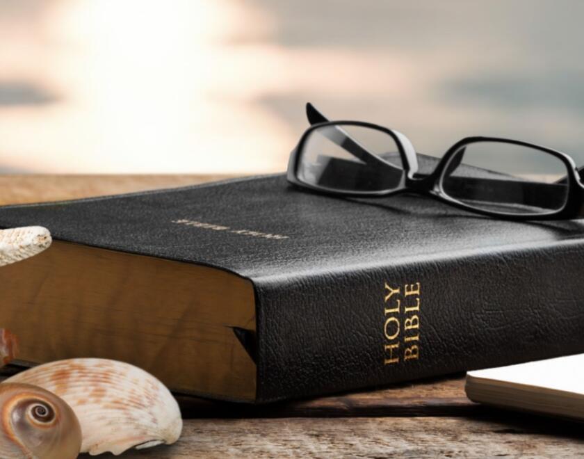 A Bible on a sunny beach