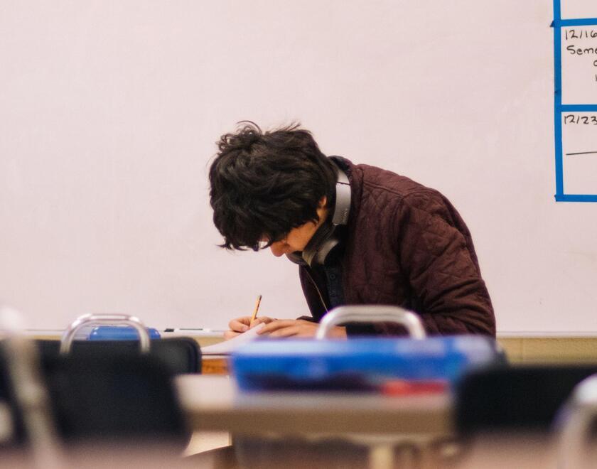 A pupil sitting alone in a classroom